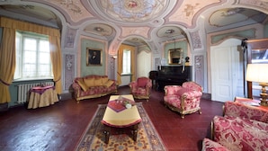 A room with ornate ceiling decorations, a piano, and vintage furniture. - tenuta la violina (Asti)