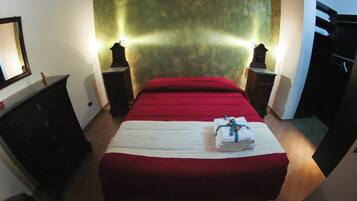 Ein Schlafzimmer mit Bett, Schminktisch, Nachttisch und Spiegel.