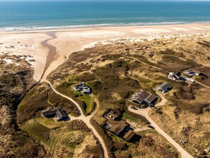 An aerial view of a coastal area with houses and a beach.