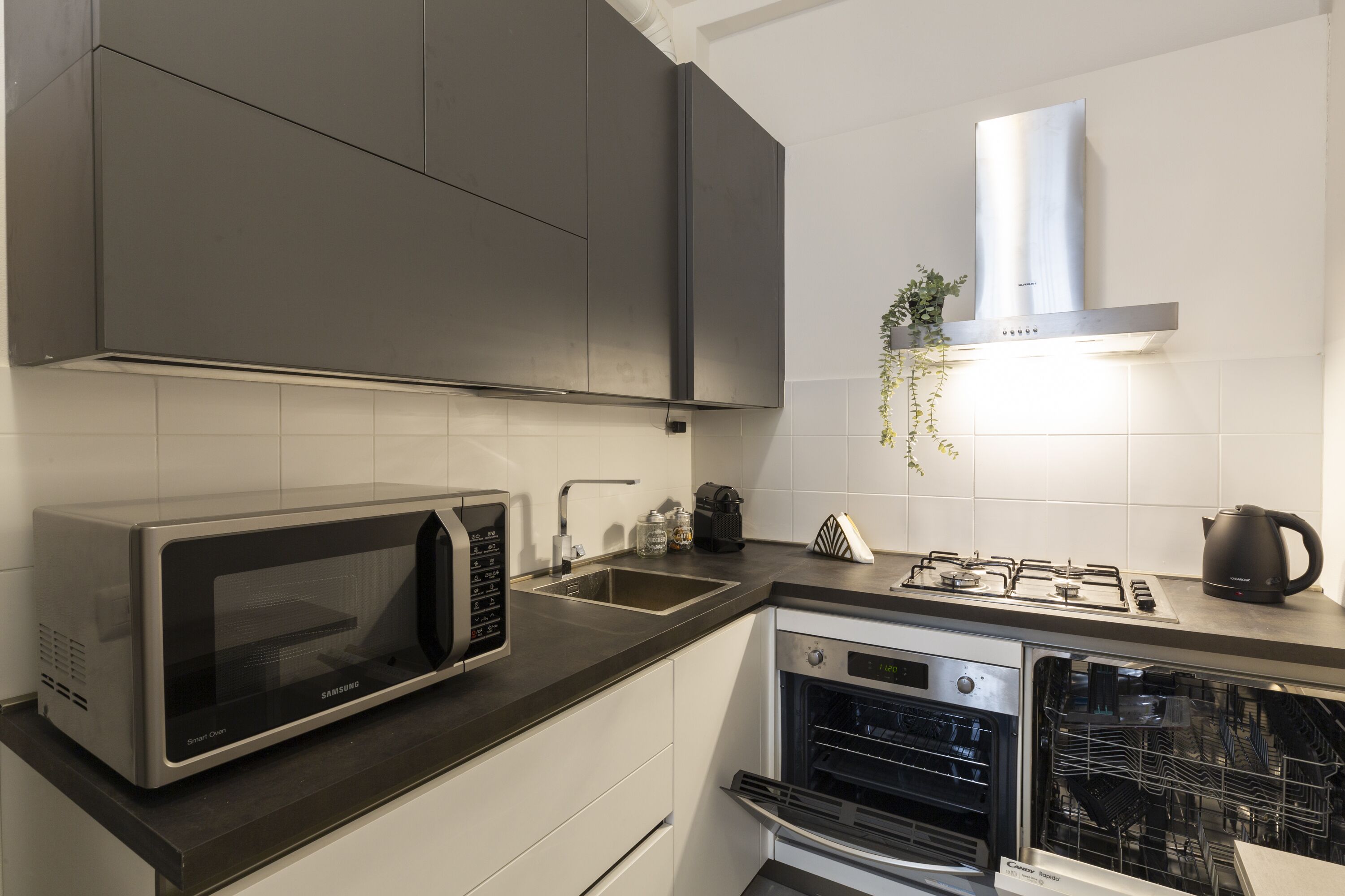 A modern kitchen with a built-in microwave, gas stove, and dishwasher.