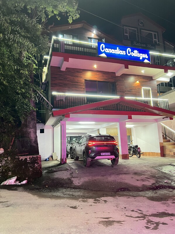 A multi-story building with a sign reading "Canadian Cottages." There are cars and a motorcycle parked in front. - Canadian Cottage Dalhousie  (Dalhousie)