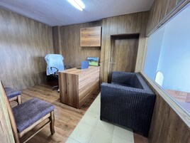 Une pièce comprenant un bureau en bois, une chaise, un canapé et un grand miroir.