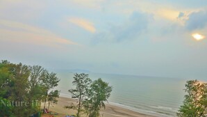 A beach with trees in the foreground and a clear sky. - Swiss Garden Residences by Nature Home (Balok)