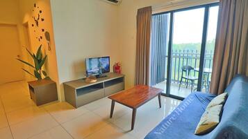A modern living room with a sofa, a wooden coffee table, a TV, and a balcony with outdoor furniture.