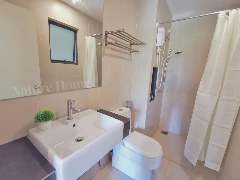 A modern bathroom with a sink, toilet, and shower.