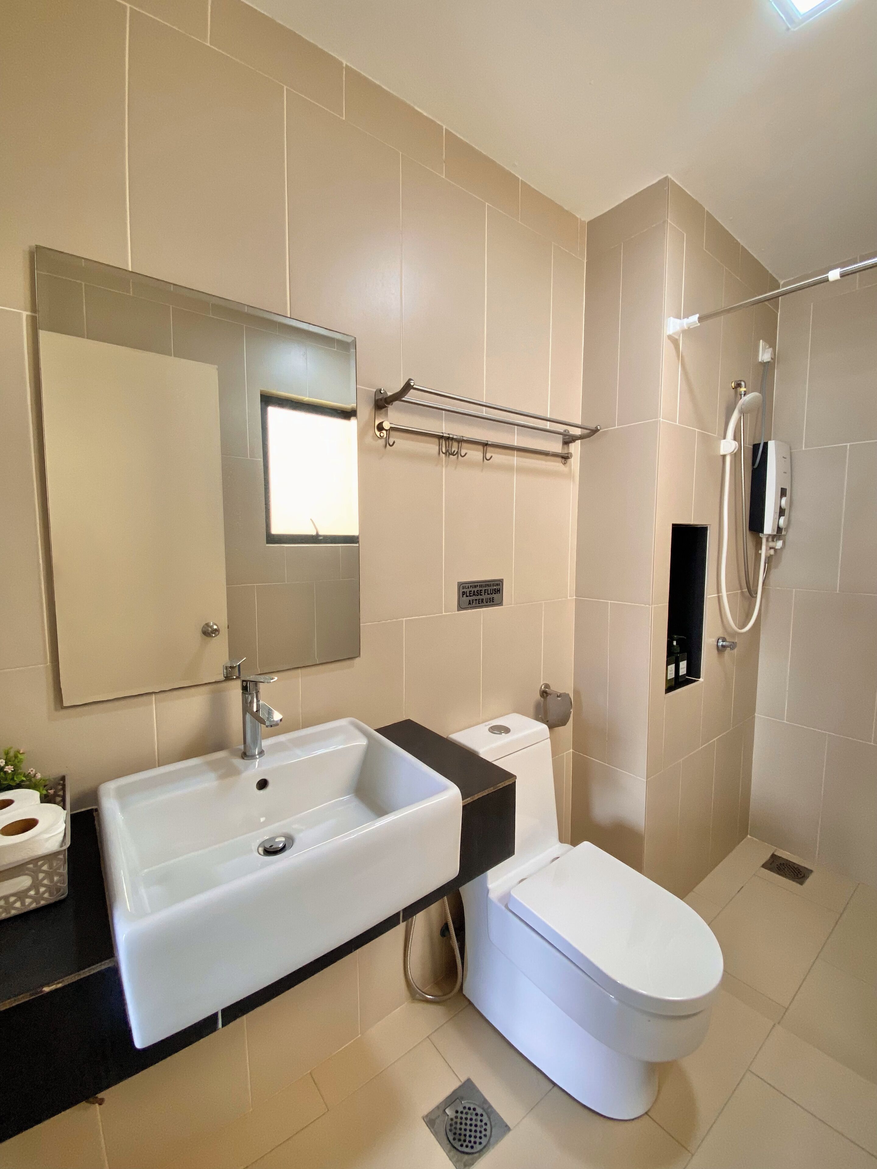 A modern bathroom with a large sink, toilet, and shower.