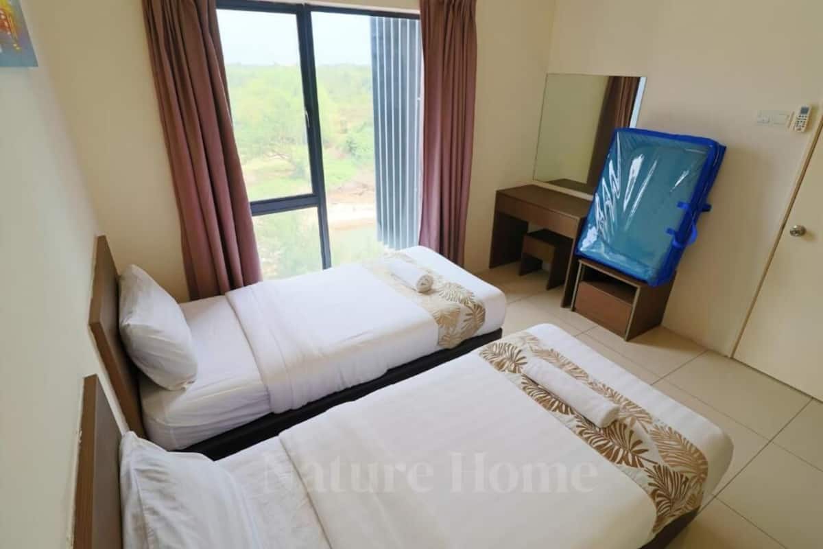 Une chambre d’hôtel avec deux lits simples, un bureau, une chaise, un miroir et une vue sur l’extérieur.