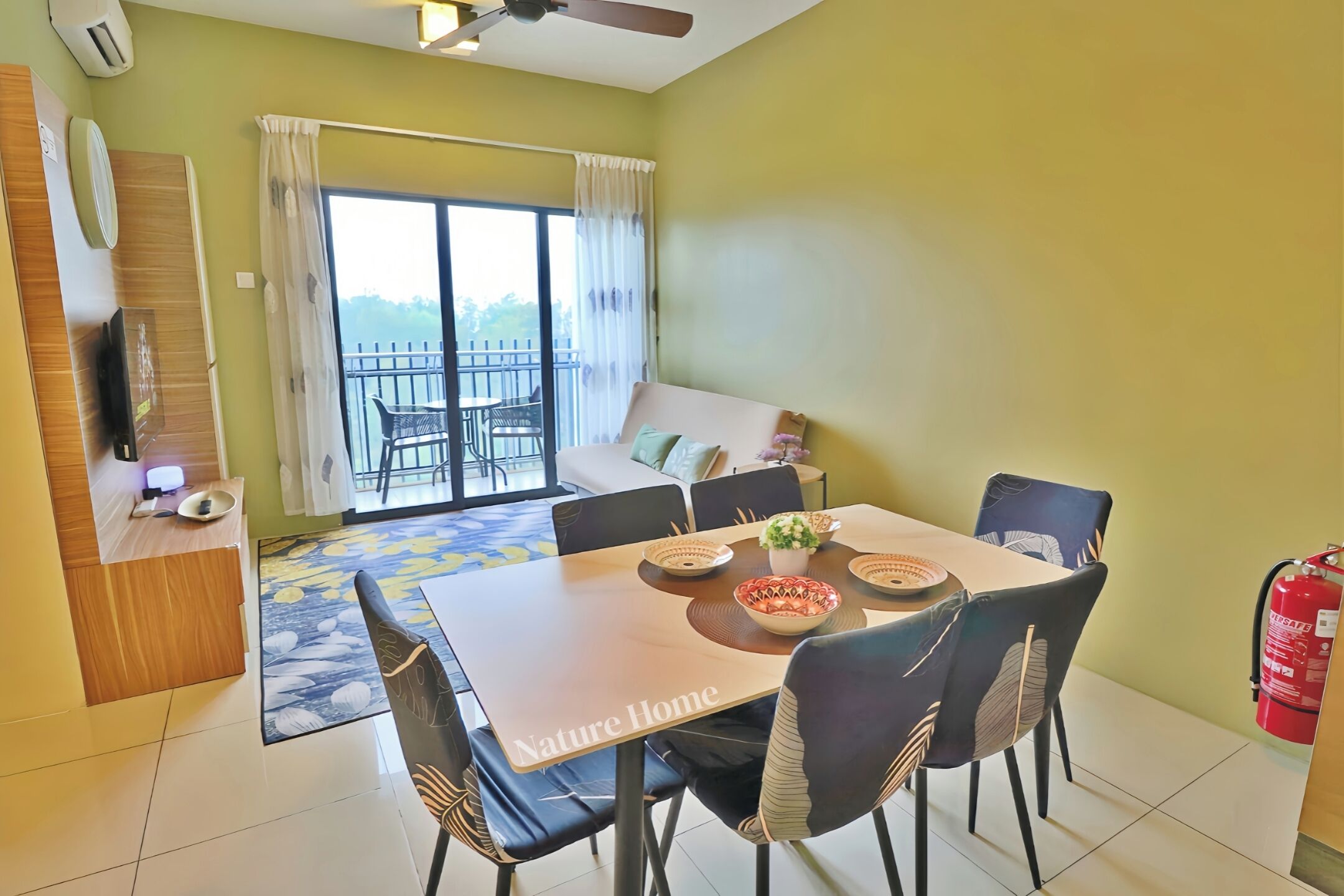 Un coin repas avec une table dressée pour quatre personnes, un canapé et un balcon offrant une vue agréable.