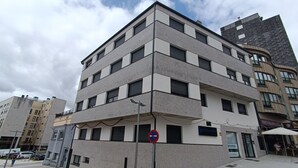 A multi-story building with a modern architectural design, featuring a mix of rectangular and square windows, and a flat roof. - Apartamentos Pontepedriña by Bossh (Santiago de Compostela)