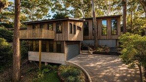A modern two-story house with a balcony, large windows, and a garage. - Architect design home, walk to Macmasters Beach (MACMASTERS BEACH)