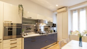 Een moderne keuken met roestvrijstalen apparatuur, grijze kastjes en een wit aanrecht.