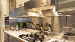Een moderne keuken met roestvrijstalen apparatuur, een wit aanrecht en een inbouwgootsteen.