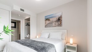 Ein Schlafzimmer mit Bett, Nachttischen, einem Schrank und einem Bild.