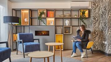 Uma área de estar moderna com lareira, assentos e uma parede decorativa com prateleiras.