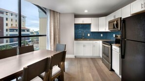 Una cocina moderna con armarios blancos, un refrigerador negro y un salpicadero azul.