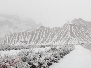 A snow-covered mountainous landscape with a narrow path leading through it.