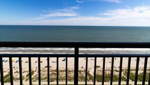 A beach view from a balcony with a railing, sandy beach, ocean, and clear sky. - Escape to the Beach or Golf: 17th Flr Oceanfront (Myrtle Beach)
