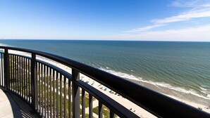 Un balcon avec vue sur l’océan et la plage.