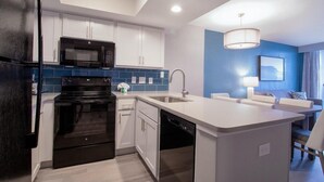 A modern kitchen with white cabinets, a black stove, and a dishwasher.