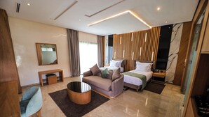 Une chambre d’hôtel moderne équipée d’un canapé, d’un lit, d’une table basse et d’un miroir.