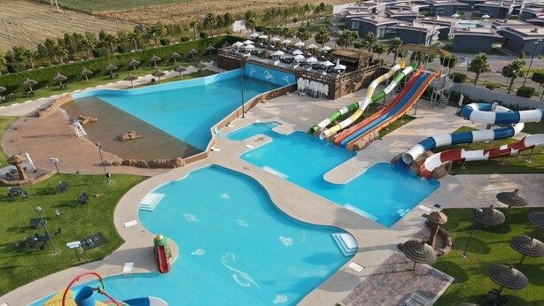 Un parc aquatique doté de plusieurs piscines, de toboggans et d’une machine à vagues.
