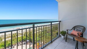 A balcony with a view of the beach and ocean.