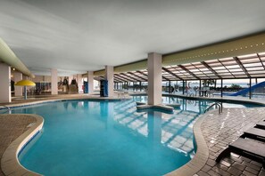 Relax by the pool surrounded by comfortable lounge chairs and a staircase leading to an upper level.