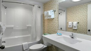 A bathroom with a bathtub, toilet, sink, and a mirror. - Your Oceanfront Oasis 9th Floor 3 Bedroom Deluxe (Myrtle Beach)