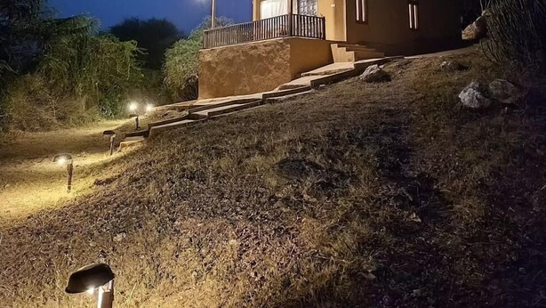 A small, single-story house with a porch, situated on a hillside. - Beyond Stay Jawai Legacy (Shivganj)