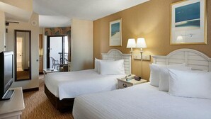 Una camera d'albergo con due letti, una televisione, una scrivania e una sedia.
