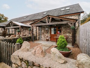 A stone building with a wooden porch, a door labeled "BARN 3", and a sign prohibiting parking. - Barn 3 (Swansea)