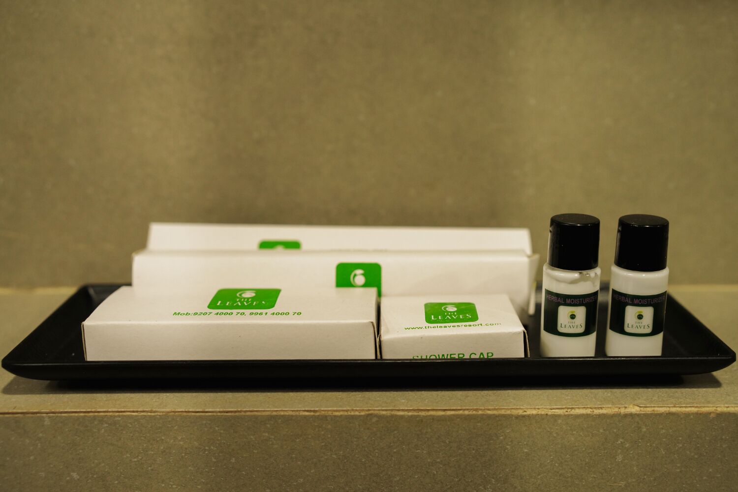 Un plateau contenant trois boîtes et deux bouteilles de gel douche, le tout portant l’étiquette « The Leaves ».