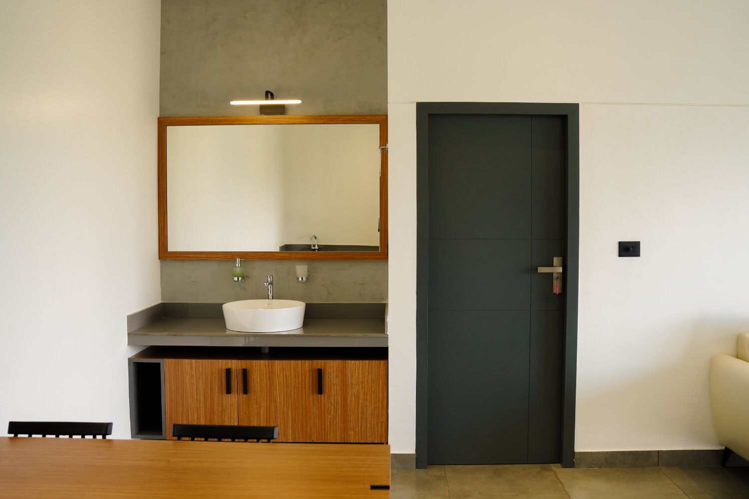 Une salle de bain moderne avec un meuble-lavabo en bois, un lavabo blanc et un grand miroir.