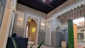 An interior with intricate tile work, a seating area, and a decorative lantern. - RIAD CONTESSA (Marrakech)