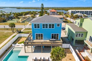 Un bâtiment à deux étages doté d’une piscine, d’un espace extérieur aménagé et offrant une vue sur l’eau.