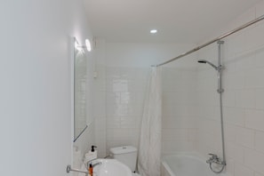 Une salle de bain moderne équipée de toilettes, d’un lavabo et d’une douche.