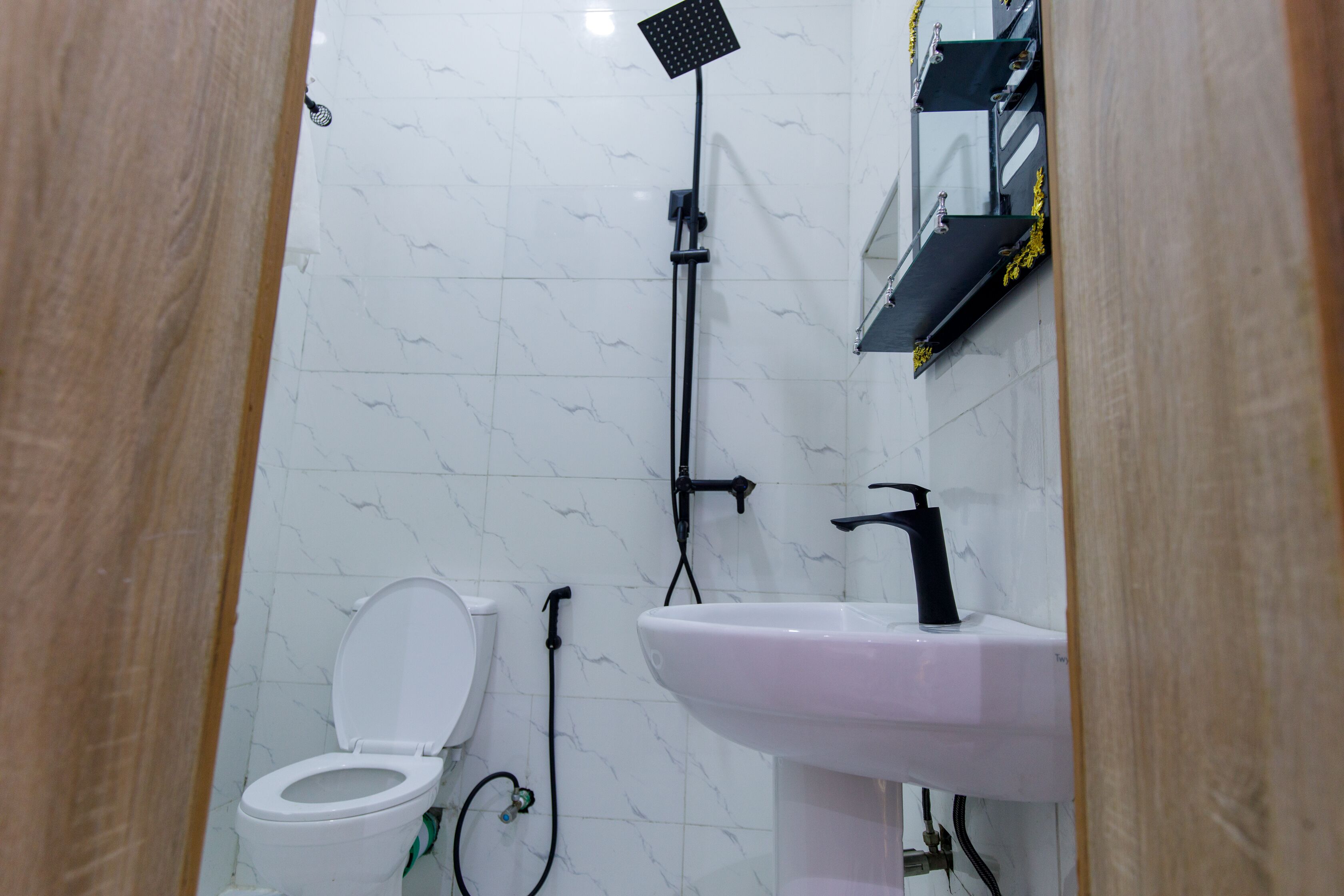 Une salle de bain équipée de toilettes, d’un lavabo et d’une douche.