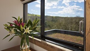 A room with a large window overlooking a landscape.