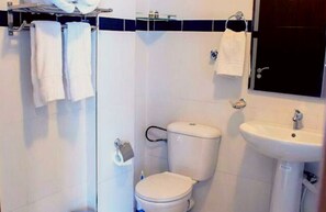 A bathroom with a toilet, sink, and towel rack. - Angle Atlas Hotel (Dir El Ksiba)