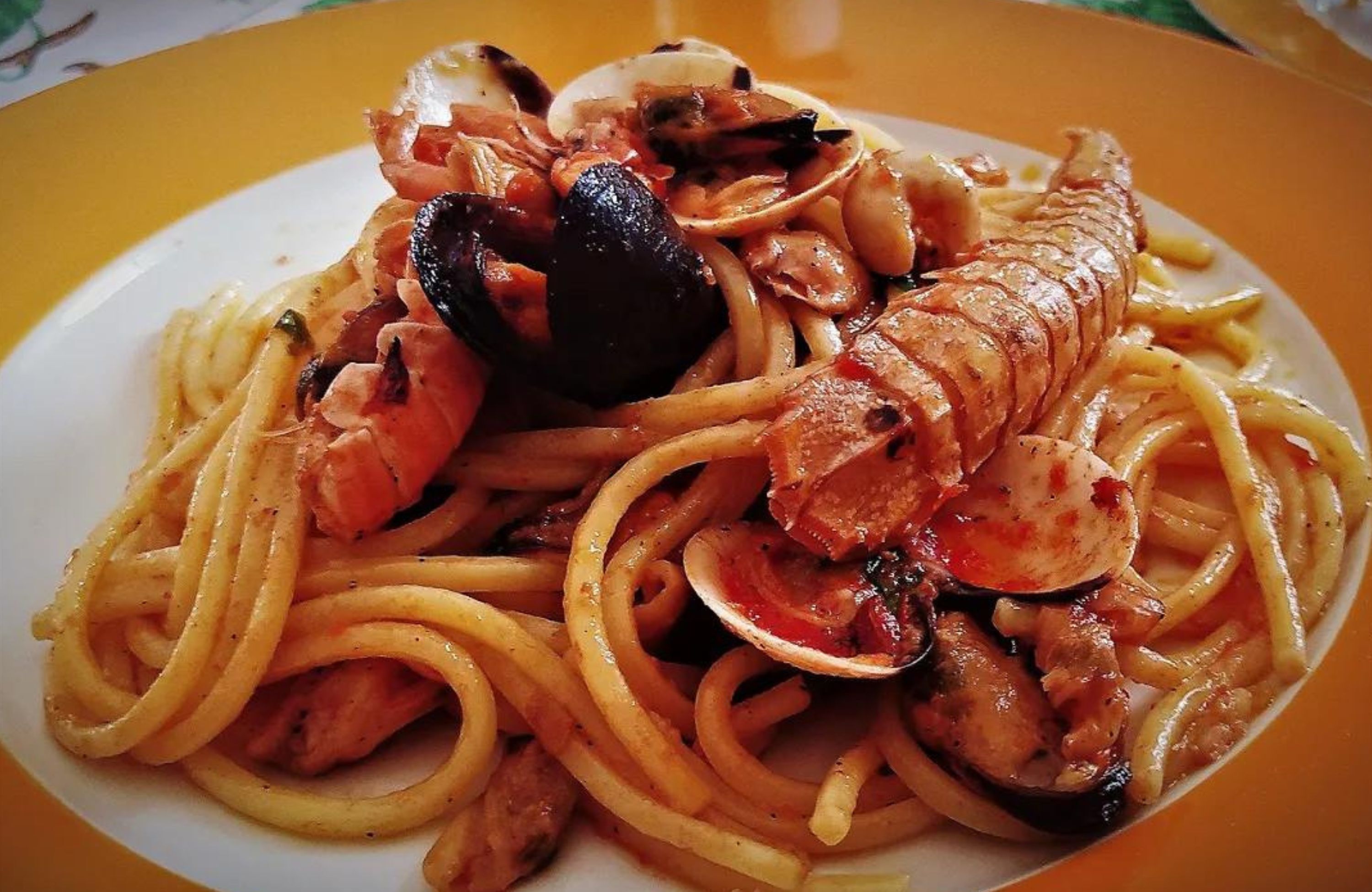 Un plato de espagueti con mariscos, incluyendo mejillones y camarones.