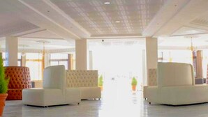 A spacious lobby with two white sofas, a large window, and a chandelier. - Angle Atlas Hotel (Dir El Ksiba)
