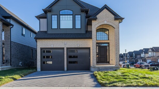 A two-story house with a garage, a brick facade, and a driveway. - Comfortable Lux | Sleeps 10 | PingPong, Cozy Family Movie Room (London)