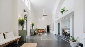A spacious hallway with a sofa, a dining area, and potted plants. - LAYAN Hotel & Spa (Quepos)