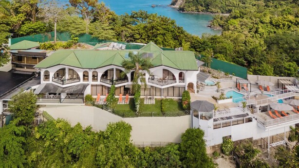 A large, modern hotel with multiple buildings, a swimming pool, and lush greenery surrounding it. - LAYAN Hotel & Spa (Quepos)