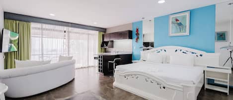Una habitación de hotel moderna con una cama grande, un sofá, un escritorio y un balcón con cortinas.