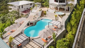 A resort with a swimming pool, outdoor seating, and a view of the ocean. - LAYAN Hotel & Spa (Quepos)
