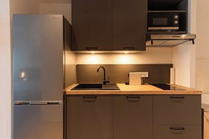 A modern kitchen with a stainless steel refrigerator, a Bosch microwave, and a sink with a faucet. - Spacious studio with pool and beach in Orient Bay (Saint-Martin)