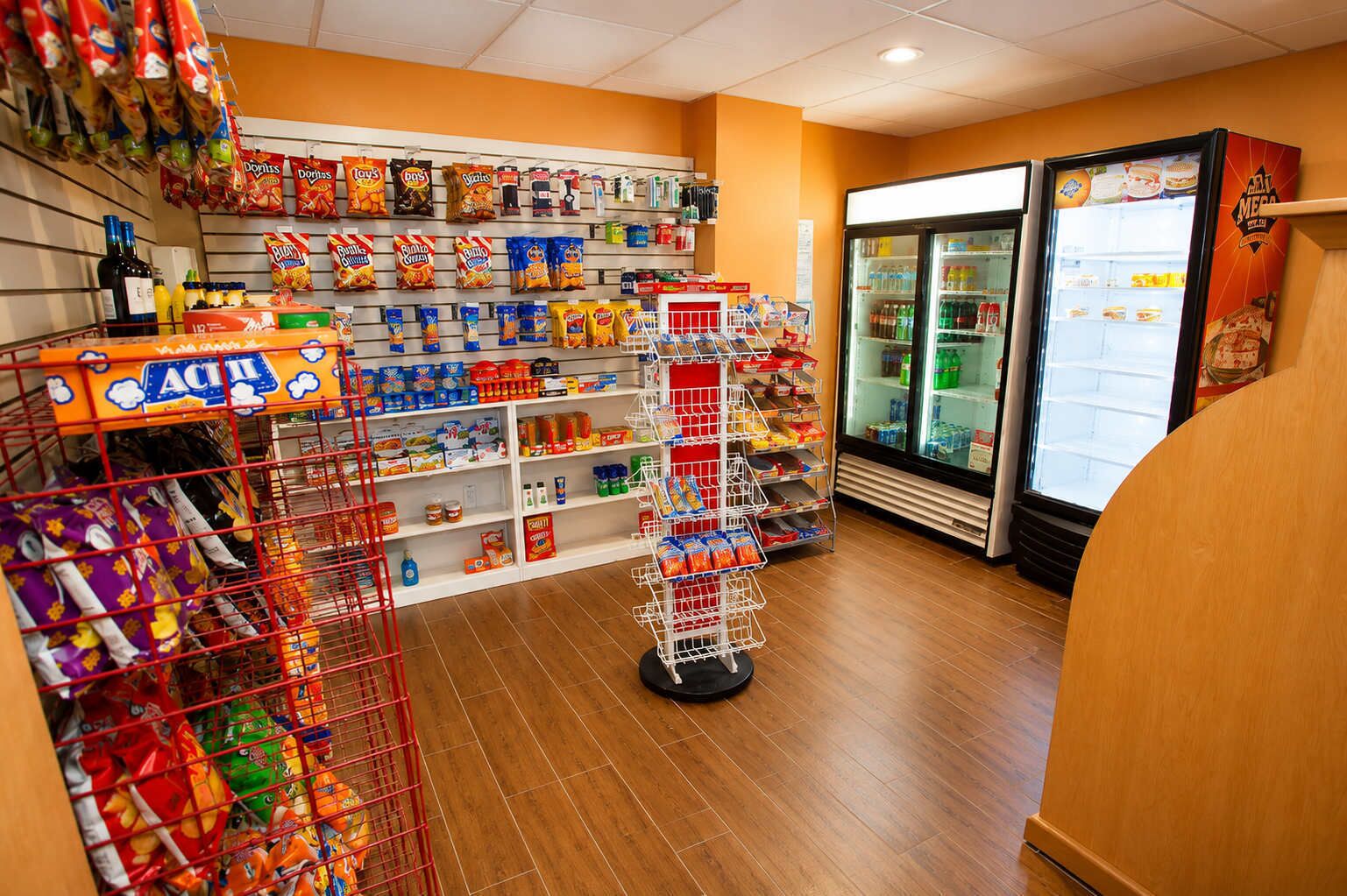 A grocery store aisle with snacks, beverages, and a refrigerated section.