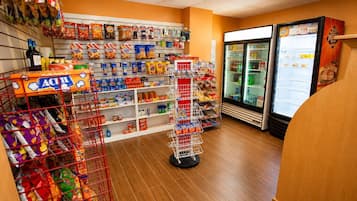 A grocery store aisle with snacks, beverages, and a refrigerated section.
