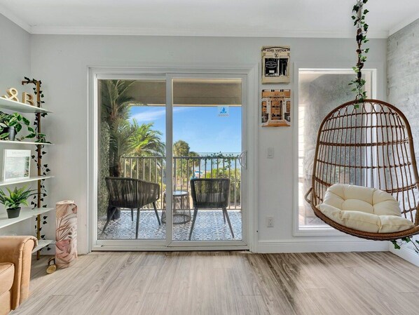 Settle into your cozy hanging chair and soak in the warm coastal breeze and lush palm views from your private balcony—your perfect retreat for morning coffee or sunset relaxation.